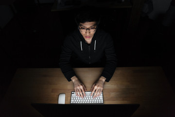 Top view of man using laptop in dark room