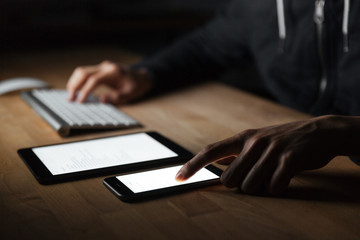 Man using blank screen and cell phone on the table