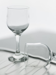 A couple of empty wine glasses, one of them fell.