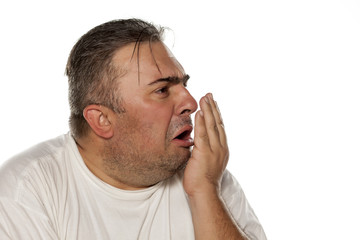 Obraz premium disgusted man checks his breath.