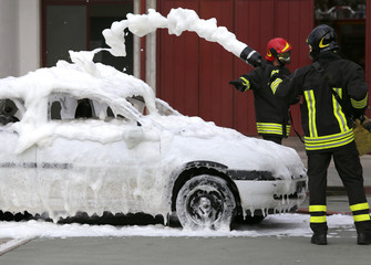 firefighters during exercise to extinguish a fire in a car