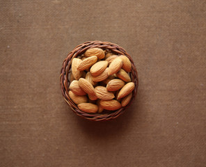 Almond on a wooden basket with against wooden background