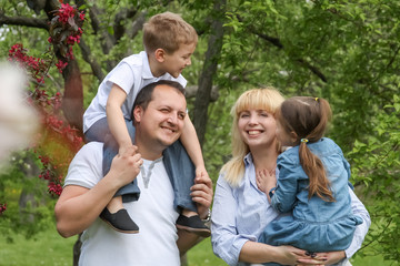 Fototapeta premium Happy family with two children in spring garden