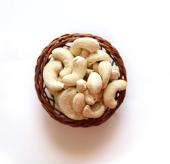 Cashews on a wooden basket with against white background