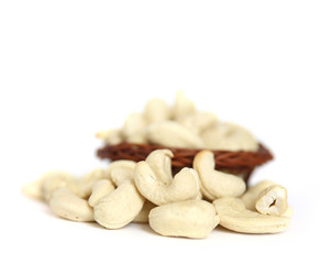 Cashews on a wooden basket with against white background