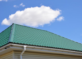 Fototapeta na wymiar Green Metal Roof and Rain Gutter House Exterior
