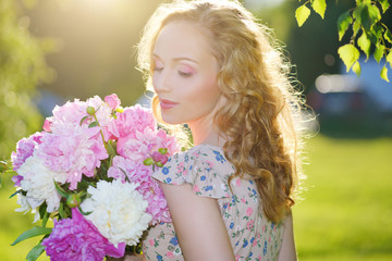 Fototapeta premium Girl with peony flowers