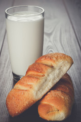 glass of milk and fresh buns on the wooden table