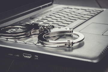 handcuffs on the laptop cyber crime concept - obrazy, fototapety, plakaty