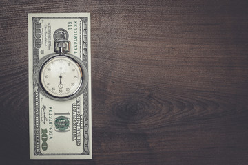 time and money concept on wooden background