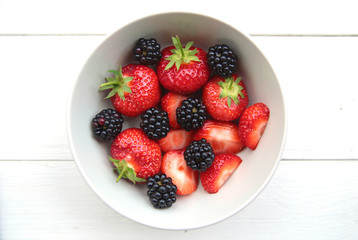 a bowl of delicate strawberries and blackberries