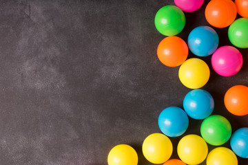 Colorfull plastic balls on the black chalkboard