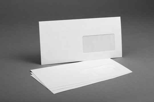 White envelope with address window on gray background.