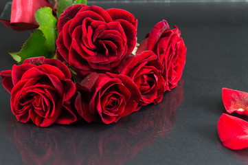 Red roses bouquet on dark mirror table
