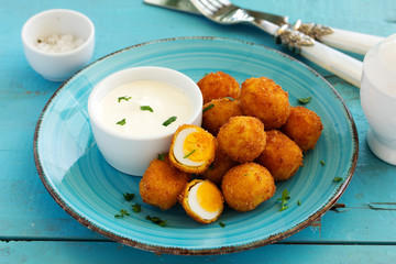 Quail eggs, deep fried with white sauce.
