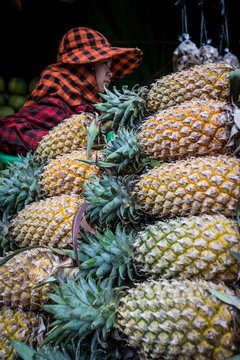 Woman selling pineapple at fruit stall in Skuon Market, Kampong Cham Province, Cambodia