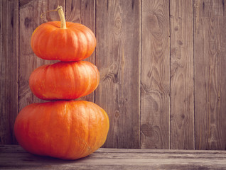 three pumpkins on wooden background