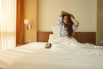 Young Asian Women wake up and Stretching while sitting in the be