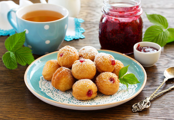 Donuts filled with raspberry jam and powdered sugar in.