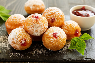 Donuts filled with raspberry jam and powdered sugar in.