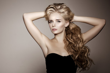 Model with blonde long hair. Waves Curls Hairstyle. Hair Salon.