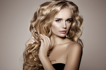 Naklejka premium Model with blonde long hair. Waves Curls Hairstyle. Hair Salon.