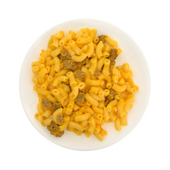 Serving of mac and cheese with hamburger chunks on plate isolated on a white background.