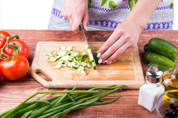 The girl cuts a cucumber