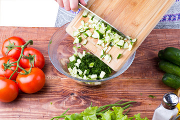 The girl cuts a cucumber