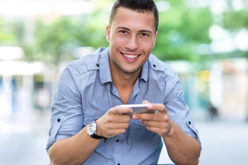 Young man with smartphone outdoors
