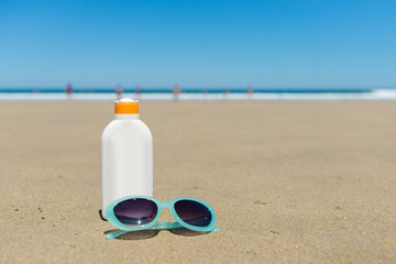 Sun lotion and sunglasses in the beach