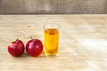 Glass of apple juice on wooden background, copyspace