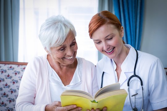 Happy Doctor And Patient Reading A Book