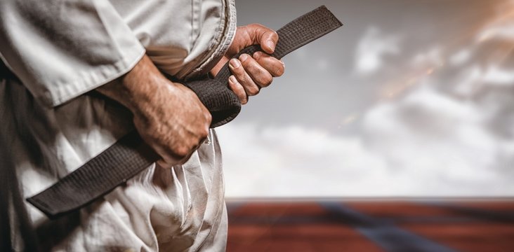 Composite image of fighter tightening karate belt