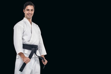 Composite image of fighter tightening karate belt