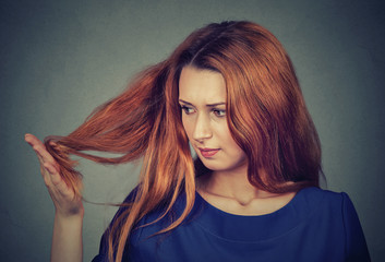 Naklejka premium upset frustrated young woman surprised she is losing hair, noticed split ends