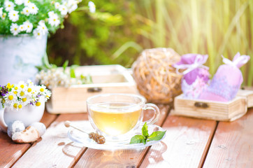 Cup of tea on a wooden backgound. Flowers and grass. Natural background. Agricultural.Garden 