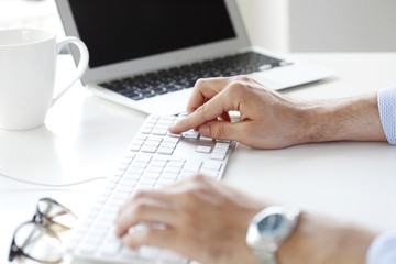 Typing on keyboard. Close-up image of hands working on a computer keyboard.