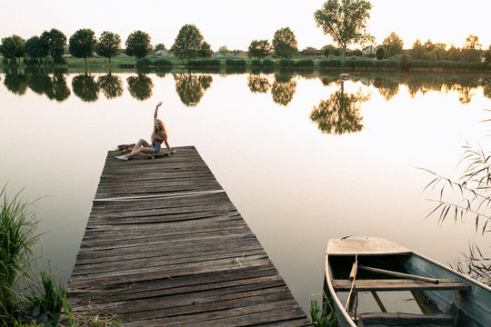 Girl sitting on pier - Powered by Adobe