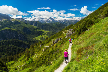 hiker on a mountain trail in the alps / Wanderer auf Wanderweg in den Alpen - obrazy, fototapety, plakaty