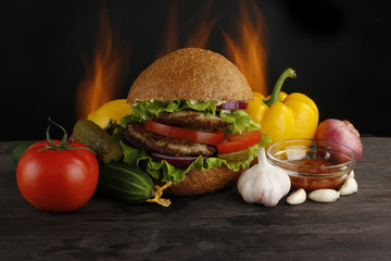 hamburger with vegetables on wooden background