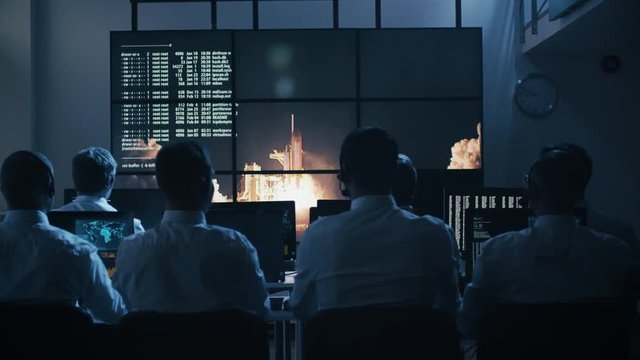 Group of People in Mission Control Center filled with Displays, Celebrating Successful Rocket Launch. Elements of this image furnished by NASA