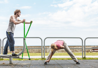 Fototapeta premium Man exercising on elliptical trainer and woman.