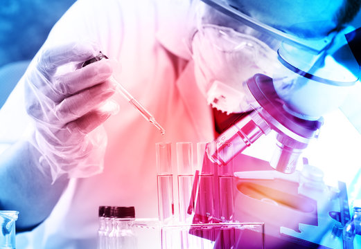 Scientist  Dropping Chemical Liquid To Flask With Lab Glassware