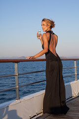 femme sur le pont d'un bateau avec une coupe de champagne