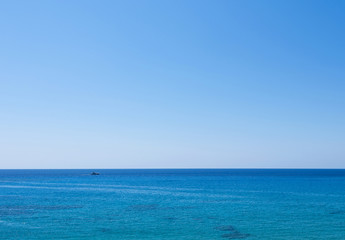 Photo of sea in protaras, cyprus island with a boat at horizon.
