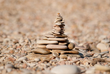 Fototapeta na wymiar The tower of stones on the beach