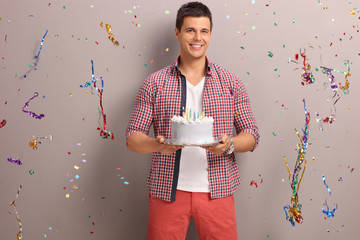 Joyful guy holding a birthday cake