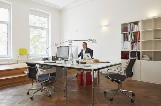 Businessman sitting at desk in an office working with computer
