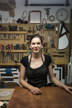 Portrait of smiling luthier in her workshop